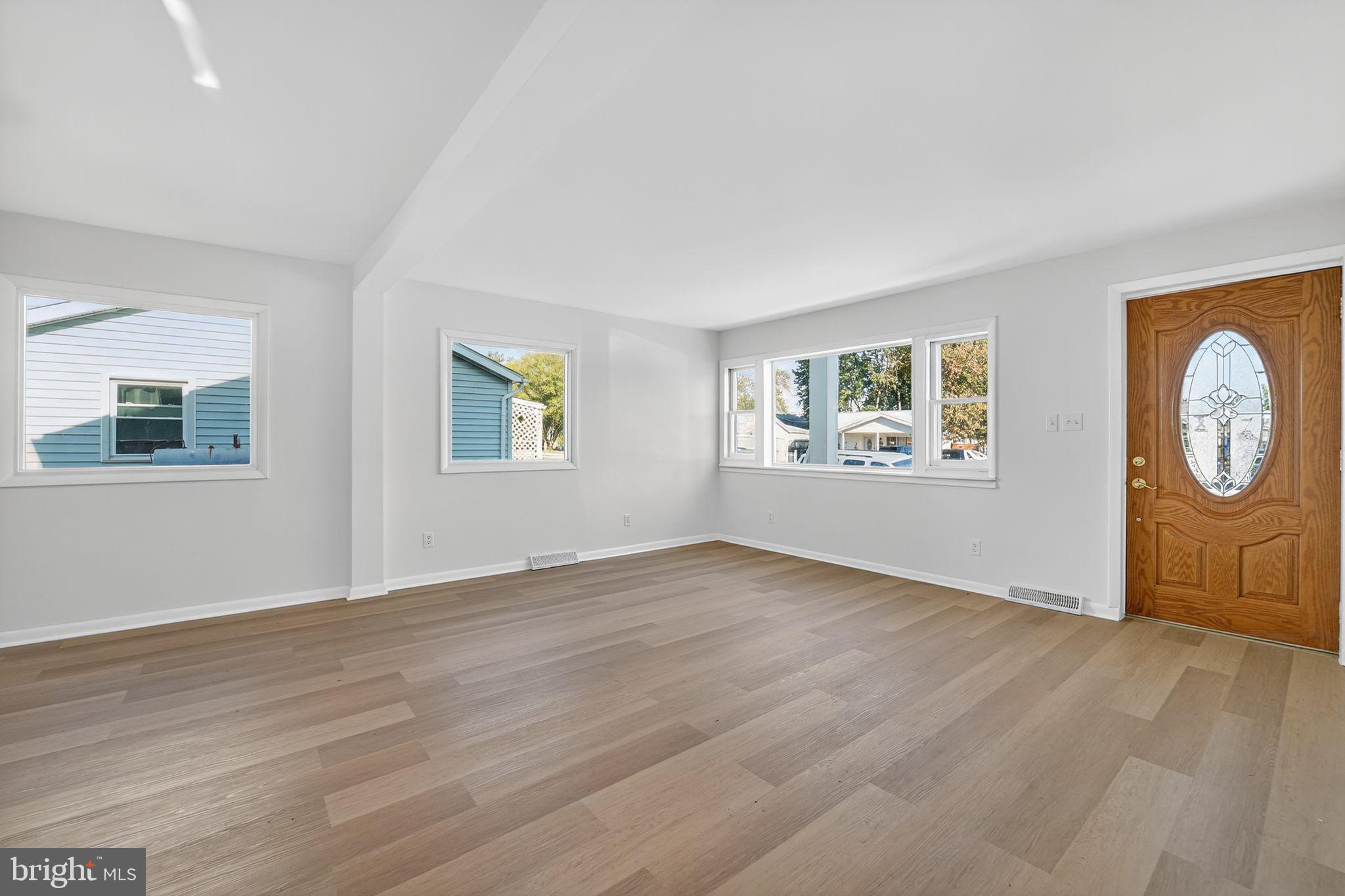 1008 Fuselage Avenue Baltimore, MD 21220 - Photo 3 of 30 a view of an empty room with a window and wooden floor
