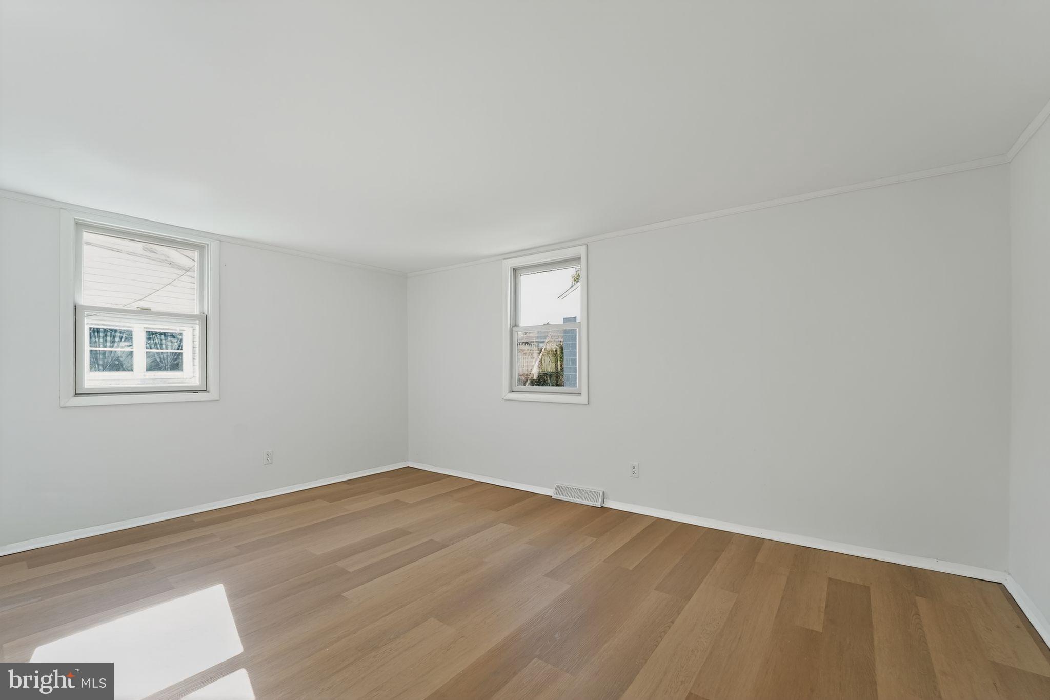 1008 Fuselage Avenue Baltimore, MD 21220 - Photo 5 of 30 a view of a big room with wooden floor and windows