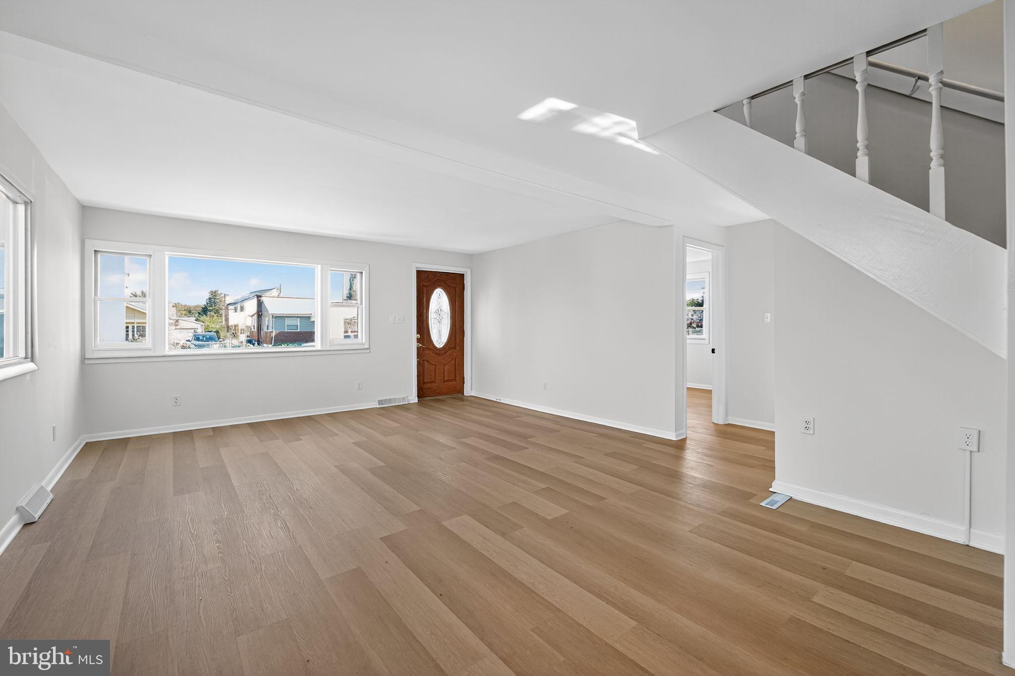 1008 Fuselage Avenue Baltimore, MD 21220 - Photo 9 of 30 a view of an empty room with a window and wooden floor