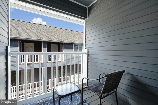 a view of a hallway with wooden floor and chandelier