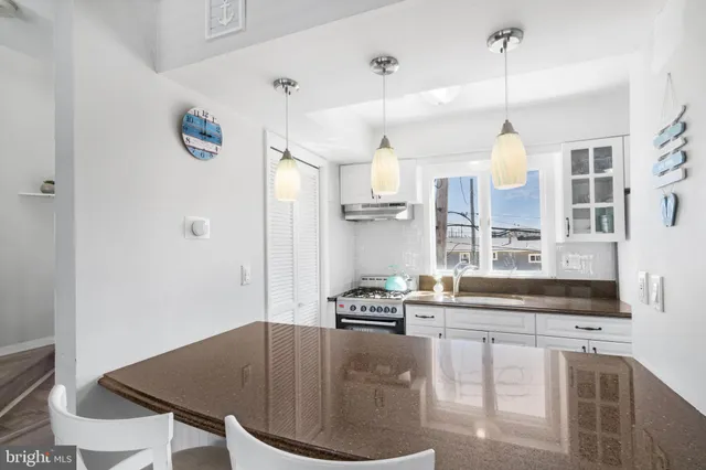 a kitchen with a dining table chairs cabinets and stainless steel appliances