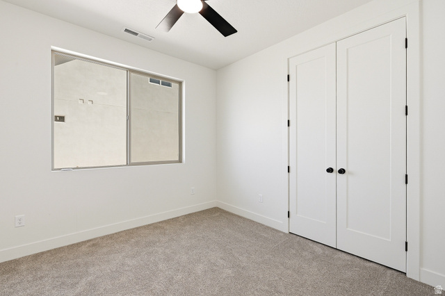 4978 North 75 East Enoch, UT 84721 - Photo 25 of 60 Unfurnished bedroom featuring light carpet, ceiling fan, and a closet