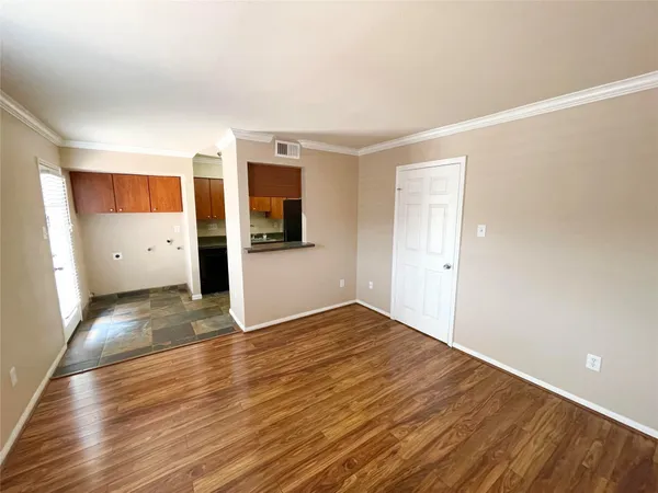 a view of empty room with wooden floor