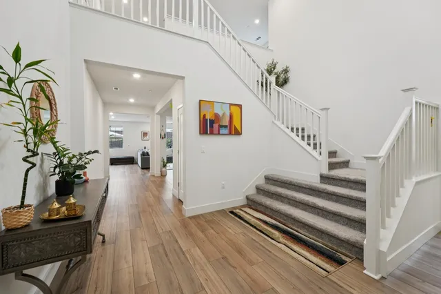 a kitchen with stainless steel appliances a dining table chairs refrigerator and cabinets