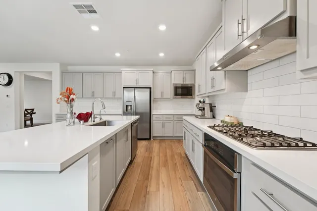 a bathroom with a double vanity sink a large mirror and bathtub