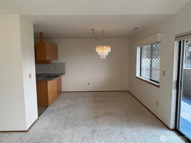 an empty room with windows and chandelier