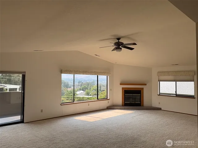 an empty room with fireplace and windows
