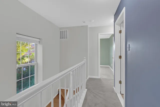 a view of hallway with wooden floor and windows