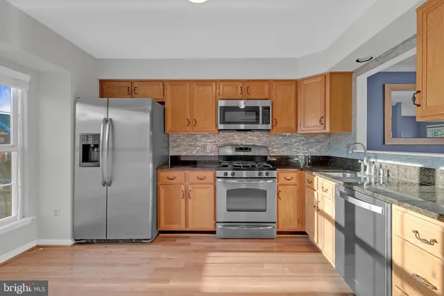 a kitchen with stainless steel appliances granite countertop a refrigerator stove and sink