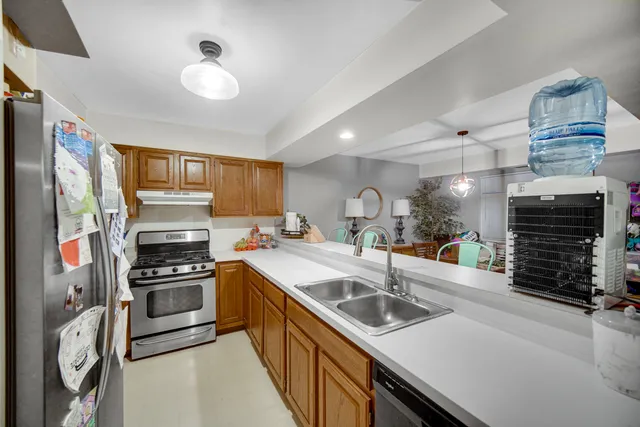 a kitchen with stainless steel appliances a stove a sink and a refrigerator