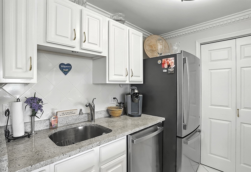 150 Staniford Street, Unit 1009 Boston, MA 02114 - Photo 11 of 25 a kitchen with stainless steel appliances granite countertop a refrigerator and a sink