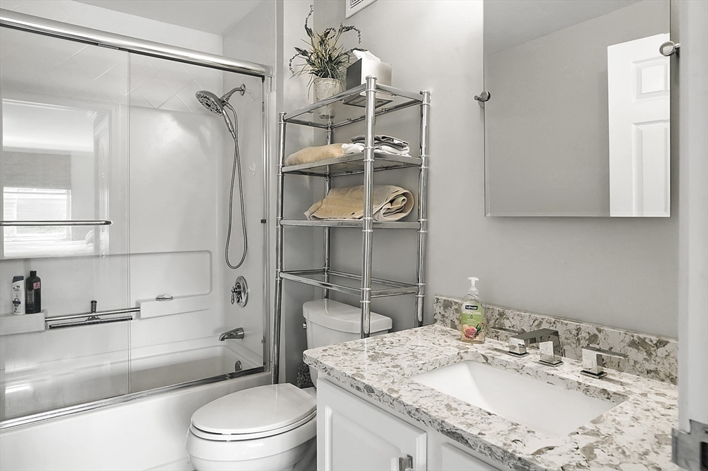 150 Staniford Street, Unit 1009 Boston, MA 02114 - Photo 8 of 25 a bathroom with a granite countertop sink toilet and shower