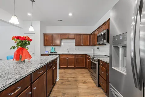 a kitchen with stainless steel appliances granite countertop a refrigerator and a sink