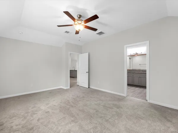 an empty room with closet and a ceiling fan