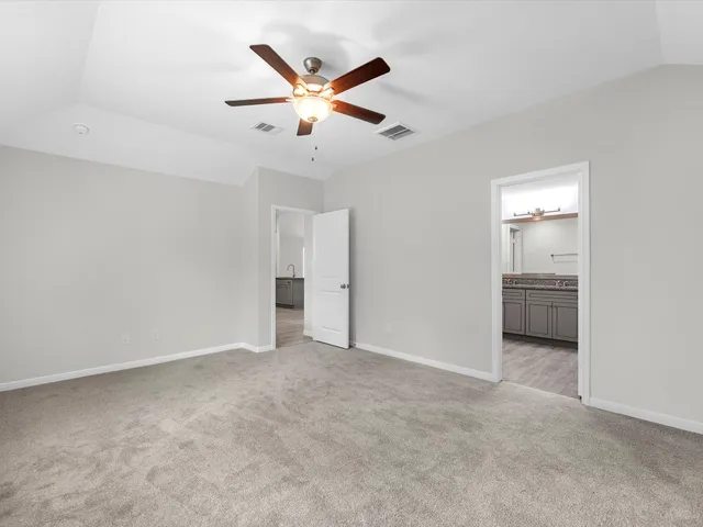 an empty room with closet and a ceiling fan
