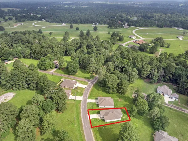 an aerial view of residential houses with outdoor space and lake view