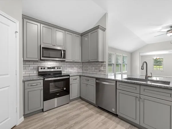 a kitchen with a sink stove and microwave