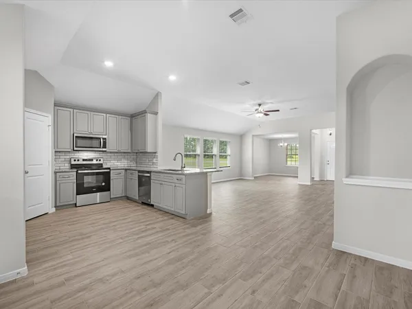 a view of kitchen with wooden floor and electronic appliances