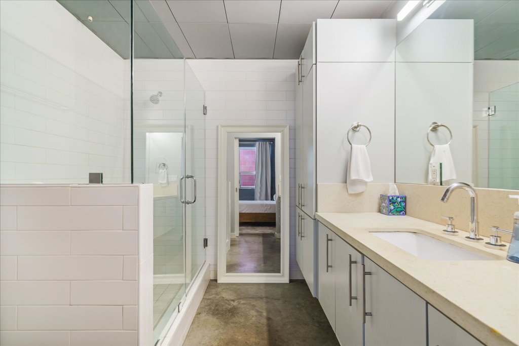 1401 Eva Street, Unit 302 Austin, TX 78704 - Photo 10 of 15 Bathroom with vanity, a stall shower, ensuite bathroom, and concrete flooring