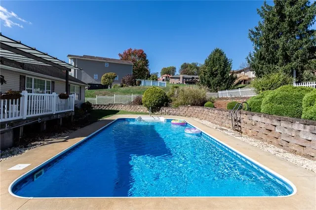 a view of a swimming pool with a patio and plants