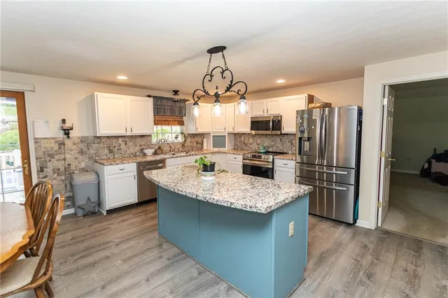 a kitchen with stainless steel appliances granite countertop a sink stove and microwave