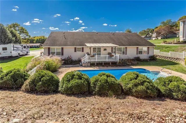 a view of a house with swimming pool and a yard