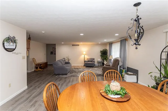 a dining room with furniture potted plants and wooden floor