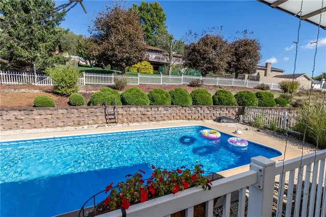 a view of house with swimming pool yard and outdoor seating