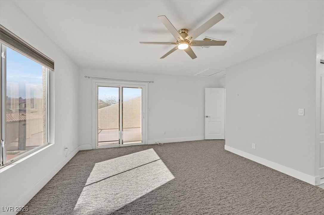 5421 Painted Mirage Road Las Vegas, NV 89149 - Photo 17 of 35 Spare room featuring a ceiling fan, dark carpet, attic access, and baseboards