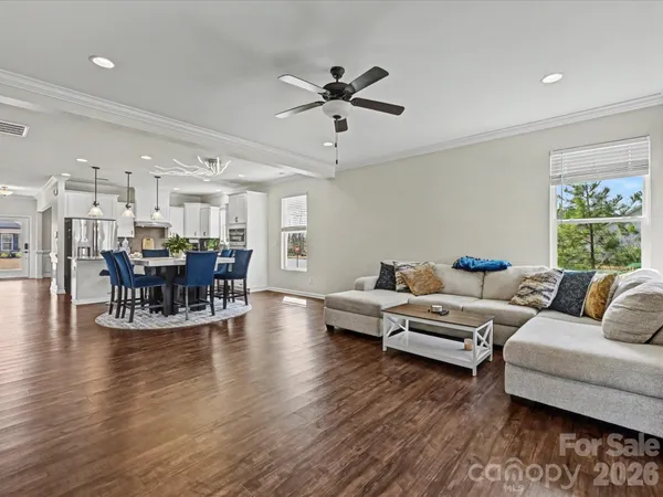 a living room with furniture and view of kitchen
