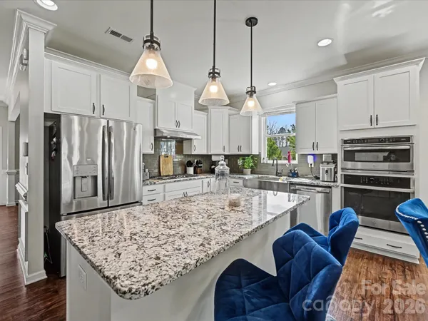a kitchen with stainless steel appliances granite countertop a sink refrigerator and cabinets