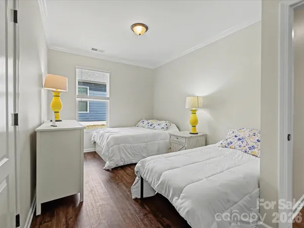 a bedroom with two beds and painting on the wall