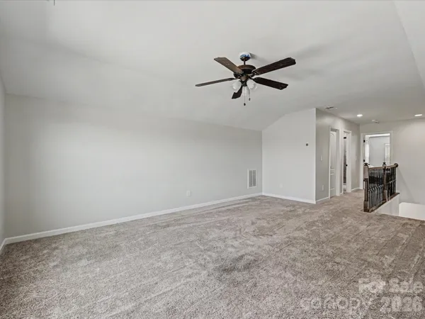 a view of a big room with wooden floor and a ceiling fan