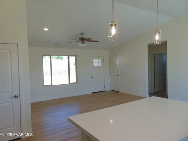 a view of an empty room with a chandelier fan