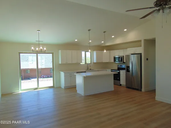 a large kitchen with granite countertop a large counter top space stainless steel appliances and a window