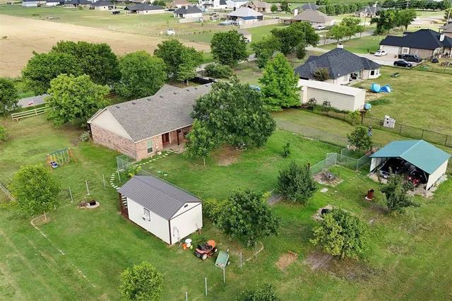 an aerial view of a house with a yard and lake view