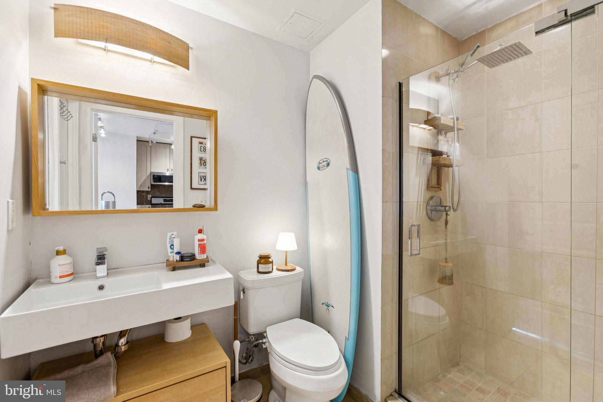 301 Massachusetts Avenue Northwest, Unit 606 Washington, DC 20001 - Photo 16 of 25 a bathroom with a sink a toilet a mirror and shower
