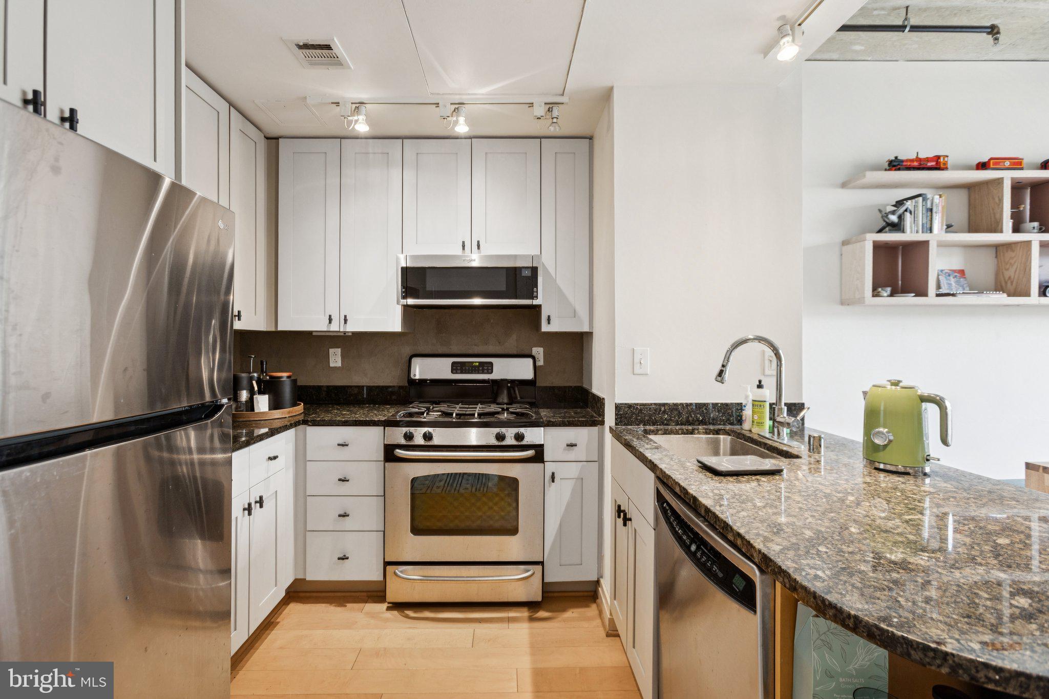 301 Massachusetts Avenue Northwest, Unit 606 Washington, DC 20001 - Photo 3 of 25 a kitchen with stainless steel appliances granite countertop a sink stove and refrigerator