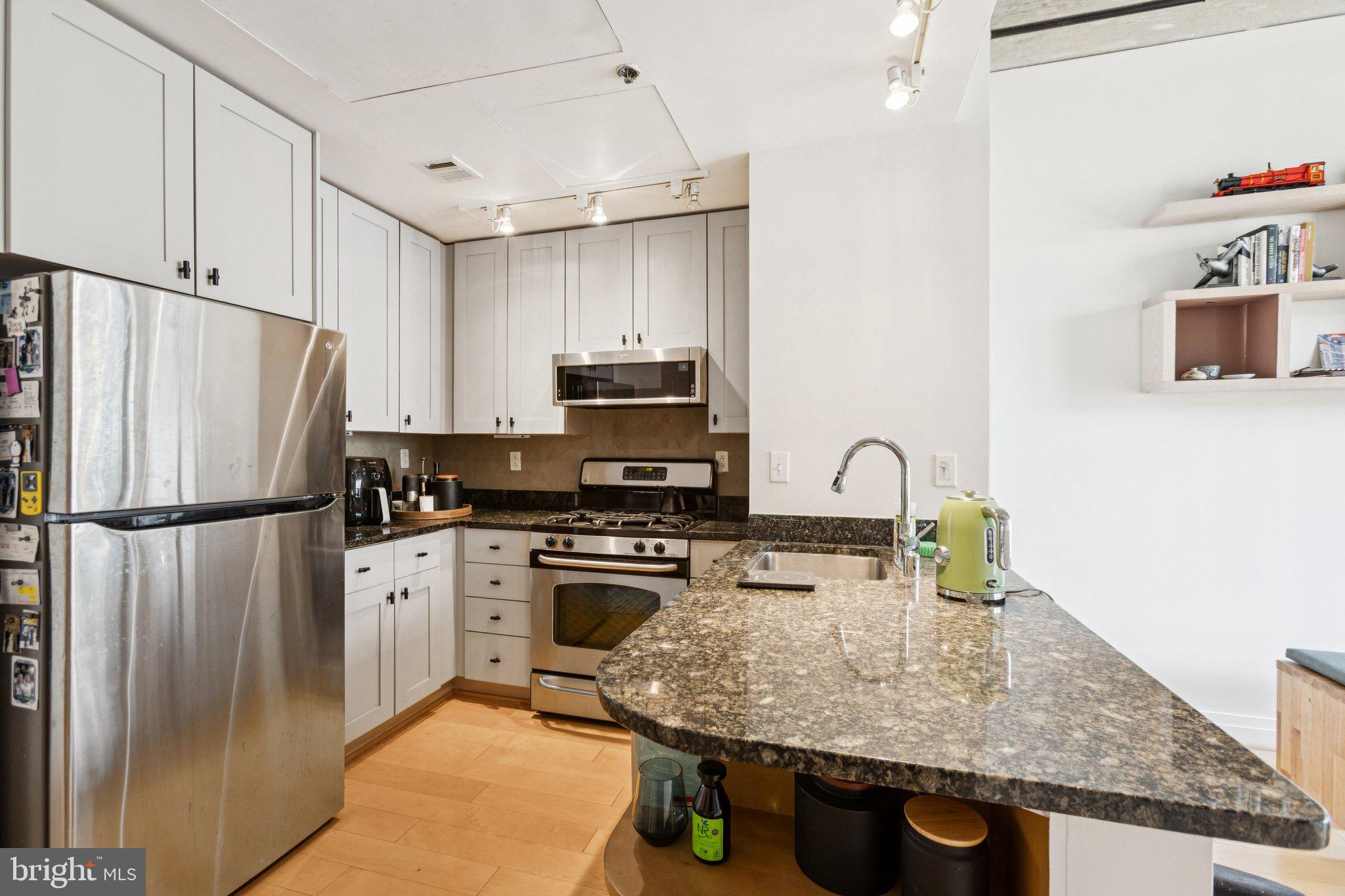 301 Massachusetts Avenue Northwest, Unit 606 Washington, DC 20001 - Photo 4 of 25 a kitchen with stainless steel appliances granite countertop a refrigerator a stove top oven a sink and dishwasher