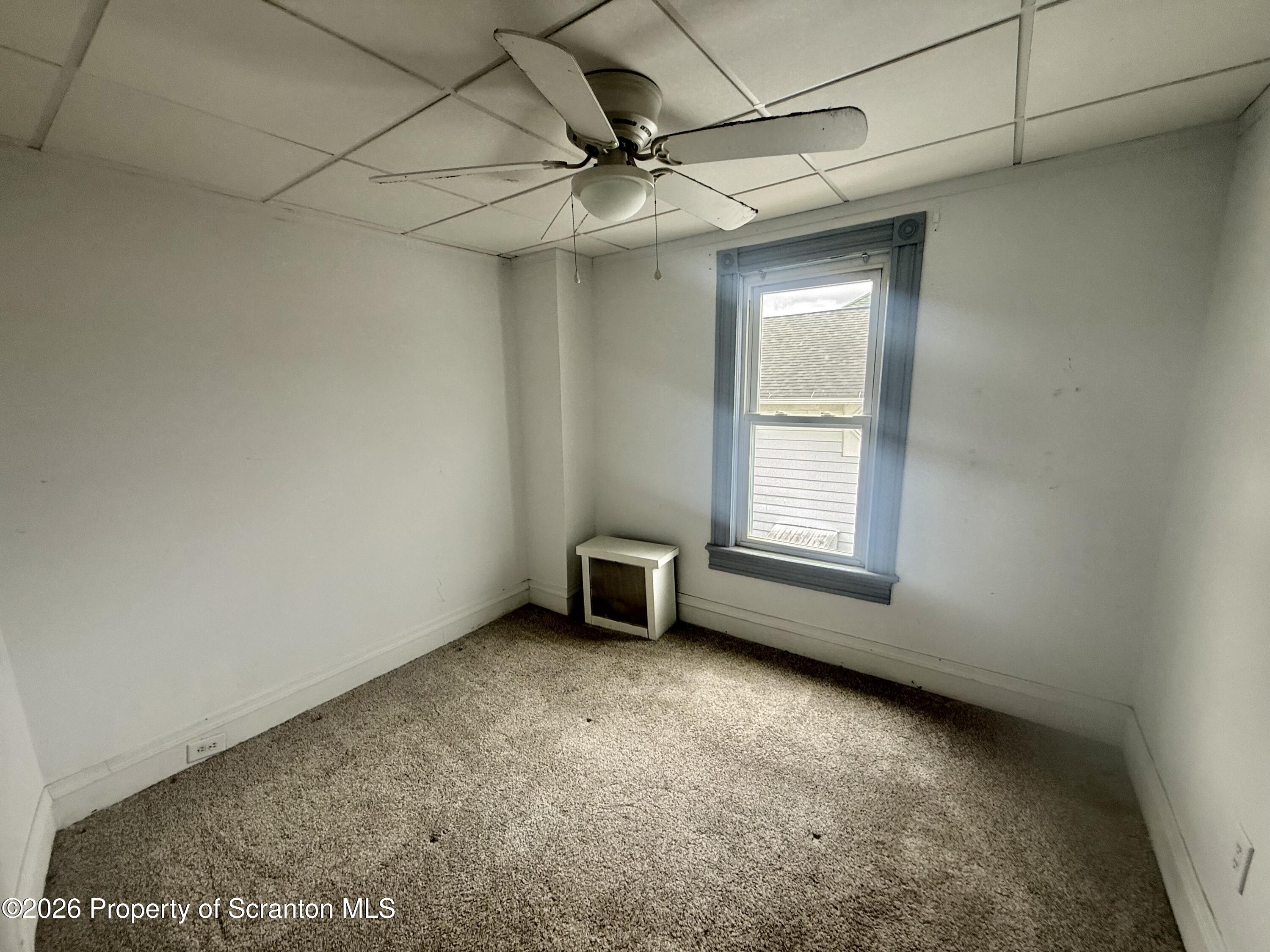 516 4th Street Dunmore, PA 18512 - Photo 5 of 8 an empty room with a ceiling fan and window