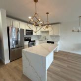a kitchen with stainless steel appliances a white stove top oven and chandelier