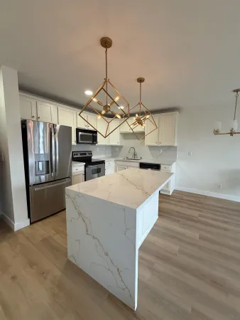 a kitchen with stainless steel appliances a white stove top oven and chandelier
