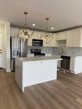 a kitchen with kitchen island a sink stainless steel appliances and cabinets
