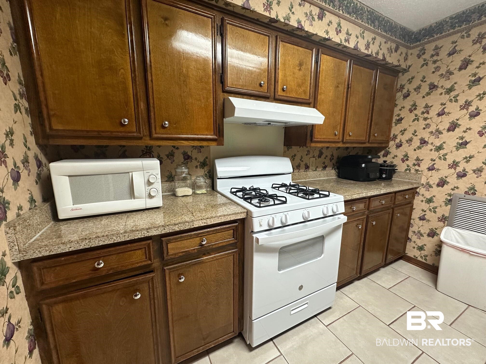 6533 Cedar Bend Court, Unit A Mobile, AL 36608 - Photo 8 of 16 Kitchen with wallpapered walls, white appliances, tile countertops, and light tile patterned flooring