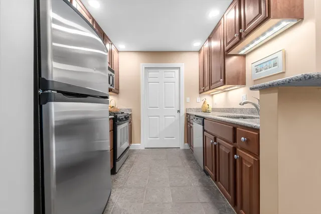 a kitchen with stainless steel appliances granite countertop a refrigerator and a sink