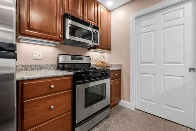 a kitchen with granite countertop cabinets stainless steel appliances and wooden floor