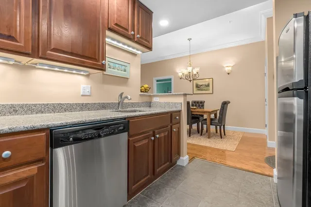 a kitchen with granite countertop a sink cabinets and stainless steel appliances