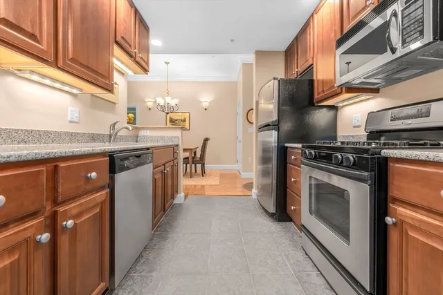a kitchen with stainless steel appliances granite countertop a stove a sink and a refrigerator