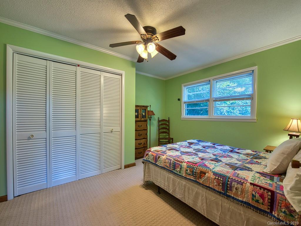 265 Shadow Ridge Sylva, NC 28779 - Photo 22 of 33 a bedroom with a bed and a chandelier