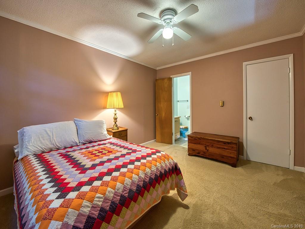 265 Shadow Ridge Sylva, NC 28779 - Photo 25 of 33 a bedroom with a large bed and a chandelier